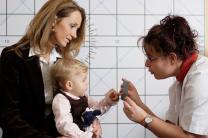 Untersuchung des Sehvermögens eines Kleinkindes durch eine Orthoptistin.
